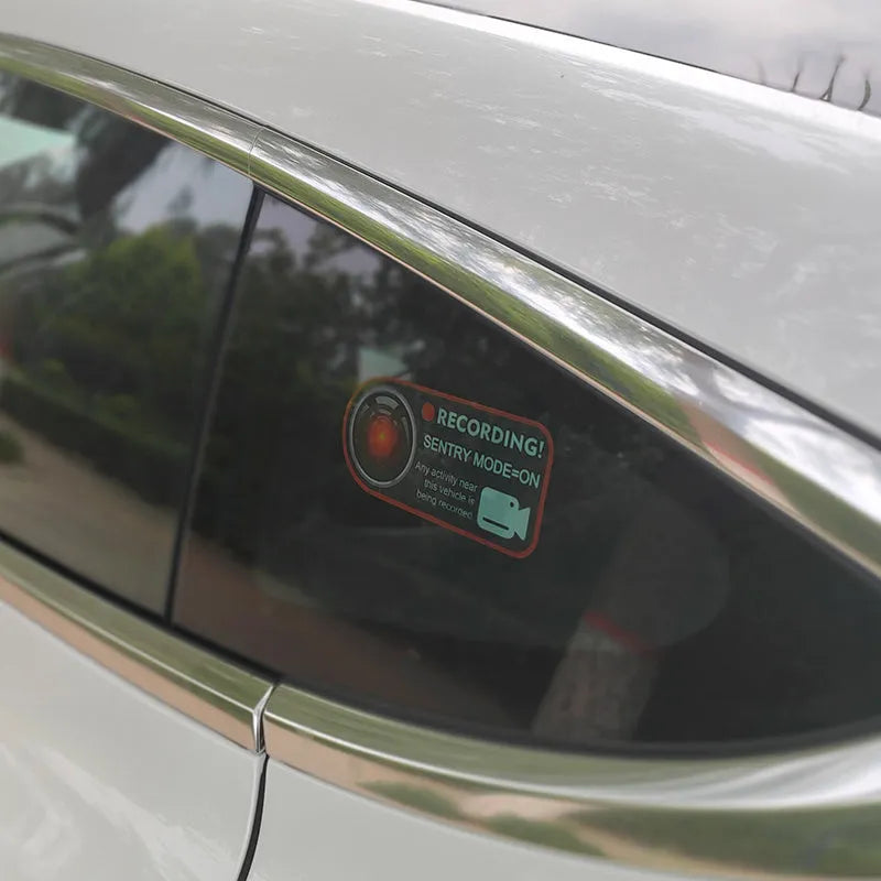 Pair of white electrostatic PVC warning stickers for Tesla car sentry mode, measuring 11 by 5 centimetres.