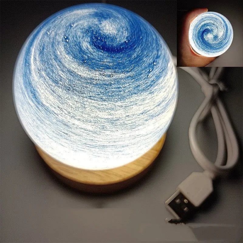 Planets themed USB night light with modern design and three-colour dimming on bedside table.
