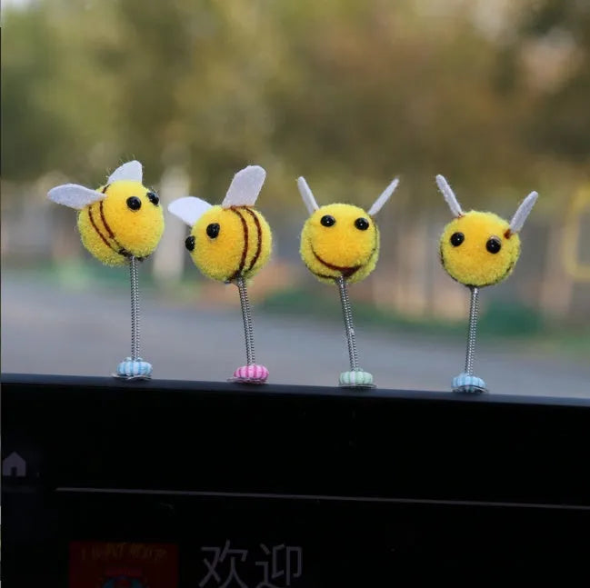 Spring-loaded bee car decoration with fur texture swinging from dashboard