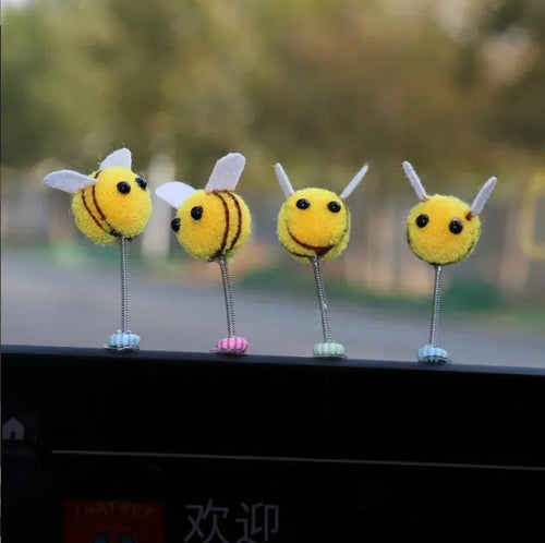 Spring-loaded bee car decoration with fur texture swinging from dashboard