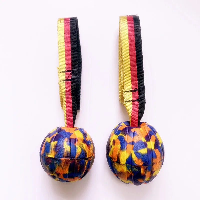Floating camouflage and yellow EVA dog training balls with string tethers in three different sizes