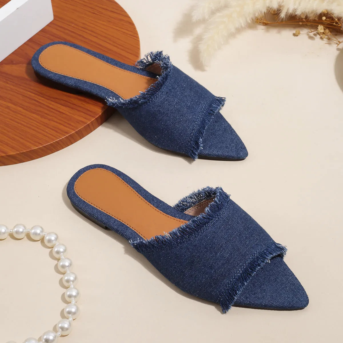 Women's denim flat slippers with tassel detail and leather lining in multiple colours.