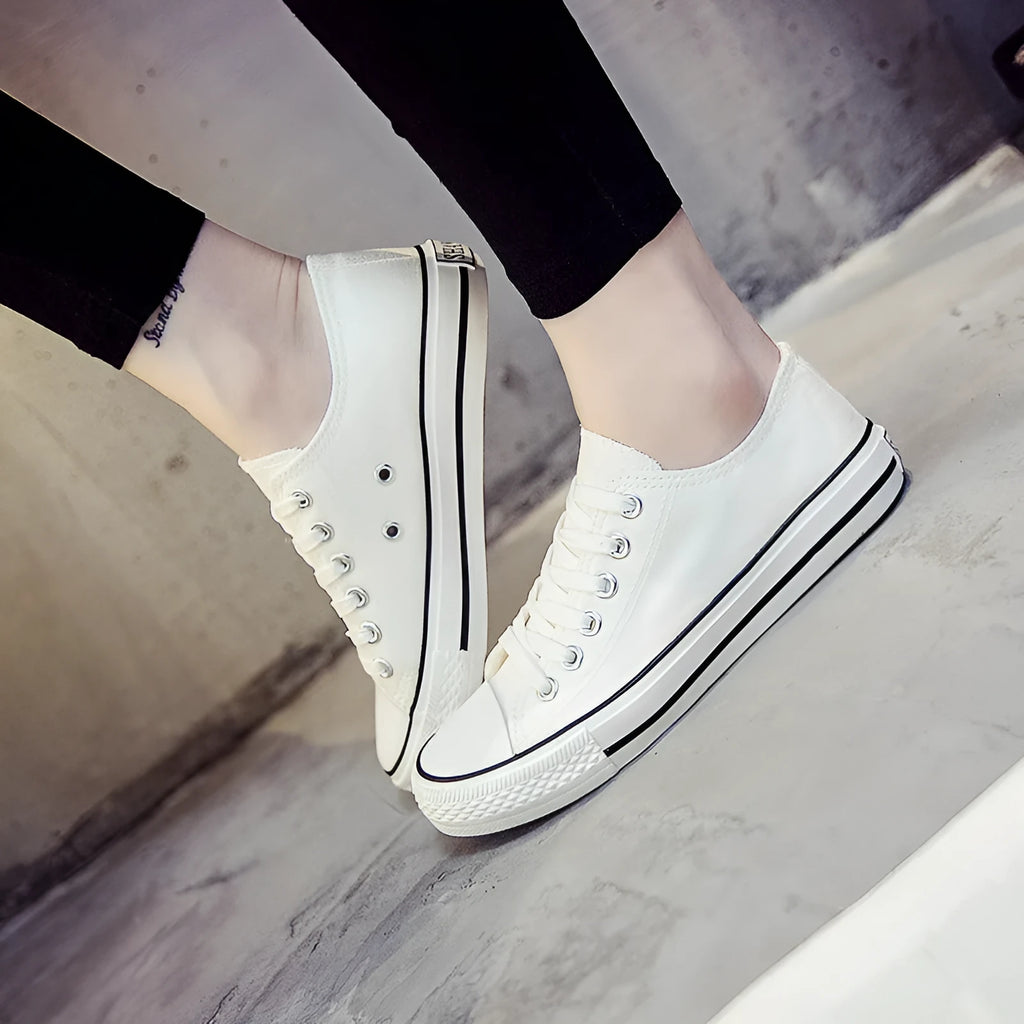 Women's canvas shoes in solid colours including black, white-black, white-red, and all-black variations
