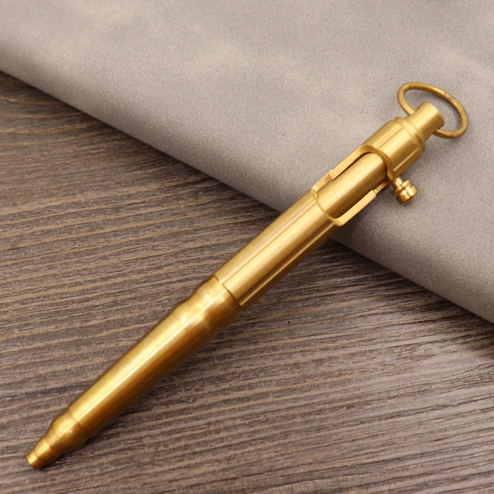 Retro brass tactical pen with press bolt-action mechanism and cylindrical metal barrel