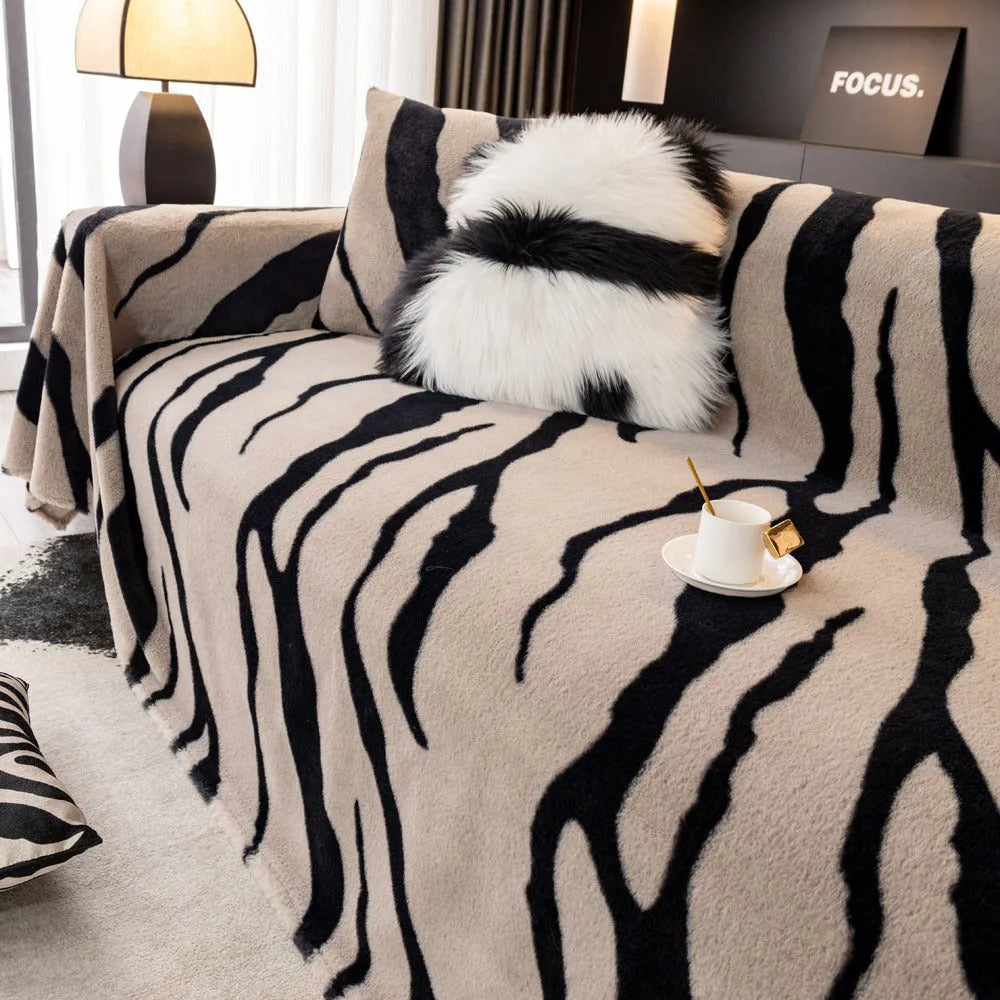 Thickened flannel zebra pattern sofa cover in caramel or black draping over a sofa with non-slip texture visible