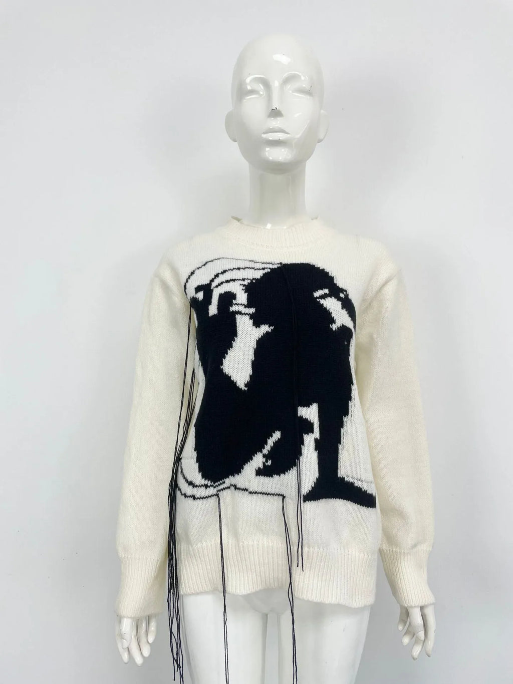 Grey women's alpaca wool pullover sweater with abstract pattern and tassel detailing on a hanger.