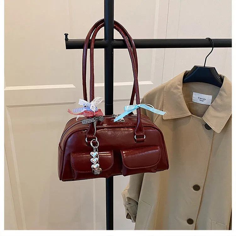 Retro brown PU leather women's pillow handbag with a flap and double shoulder strap on a neutral background.