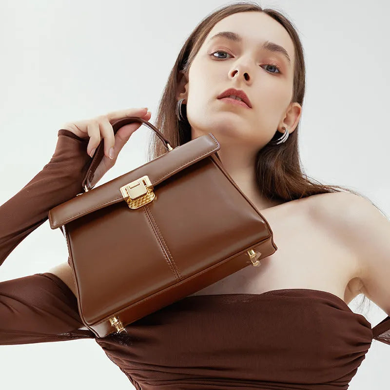 Black genuine vachette leather women's shoulder bag with clasp closure, showing square shape and adjustable strap.