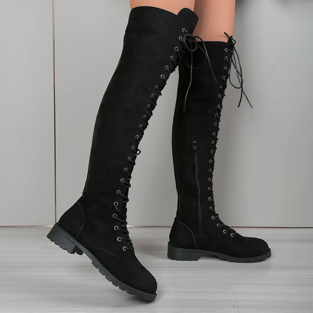 Black over-the-knee lace-up boots with round toe, flat rubber sole, and visible stitching details