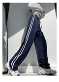 Women's navy blue loose straight leg trousers with ribbon parallel bars detail on the leg.