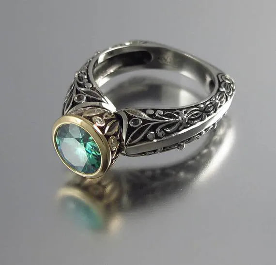 Gold-plated flower-shaped vintage ring with a green gemstone on a model's finger