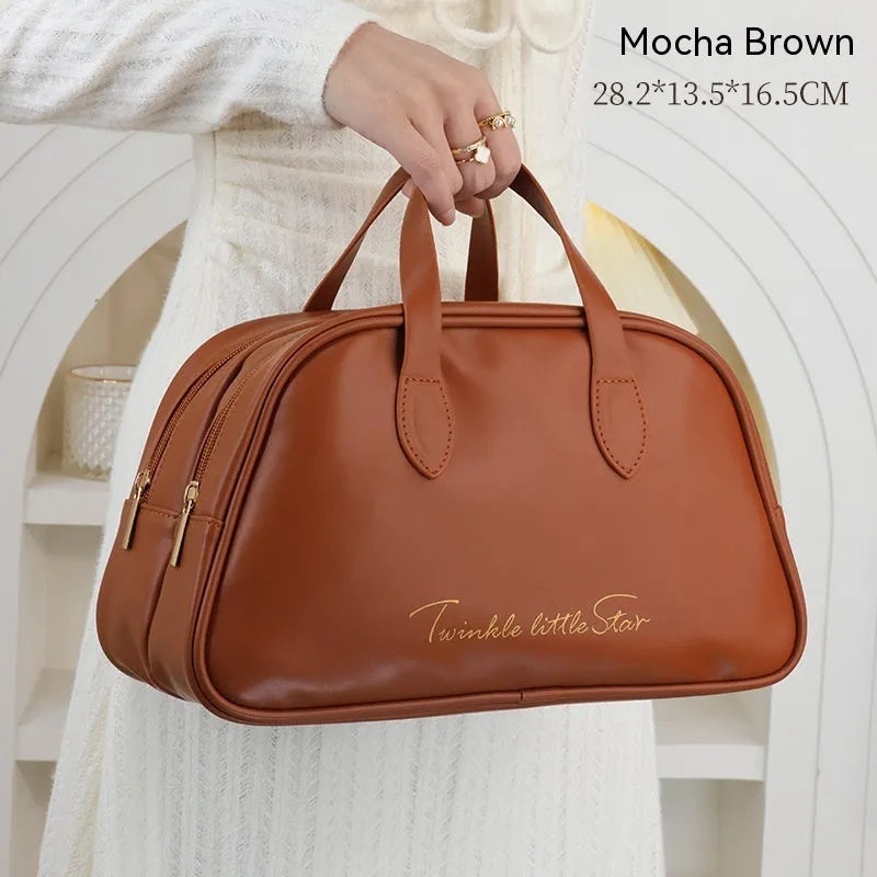 Leather travel toiletry bag in caramel mocha colour showing storage compartments and decorative letter details