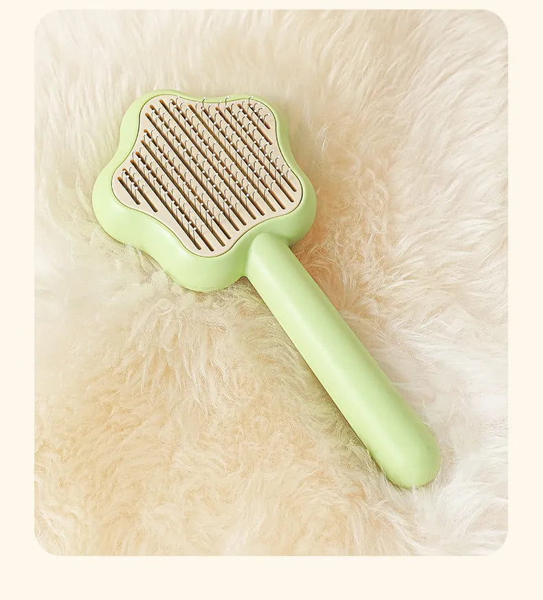Green self-cleaning stainless steel pet comb with a magic wand handle on a white background.
