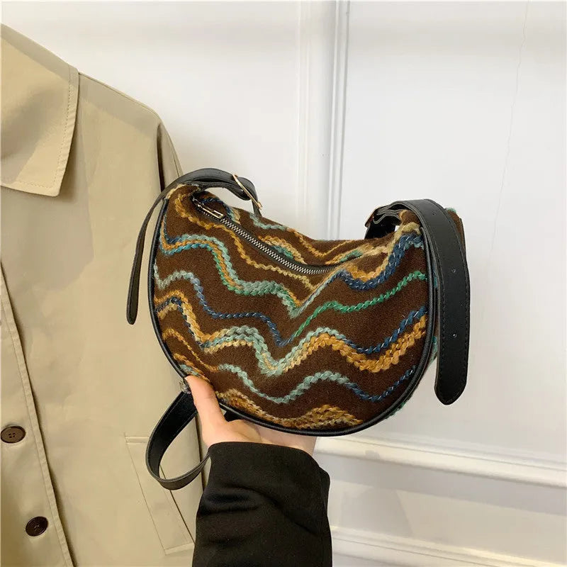 Women's straw woven crossbody bag showing knitted weaving texture and internal phone pocket