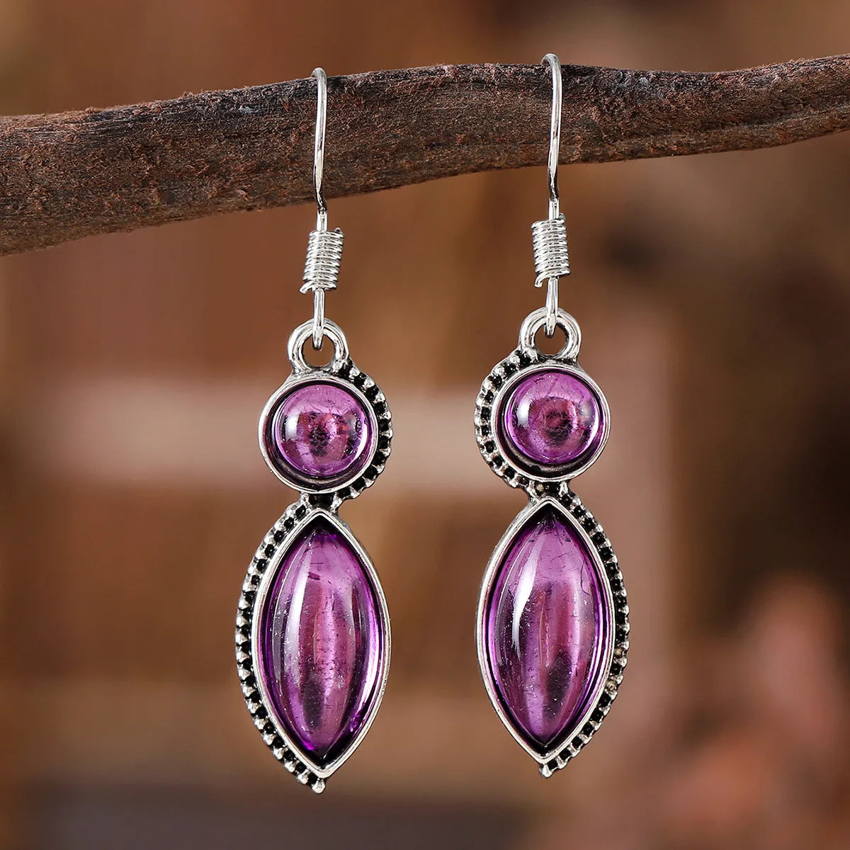 A pair of black and purple vintage geometric pendant earrings with bohemian style on a white background.