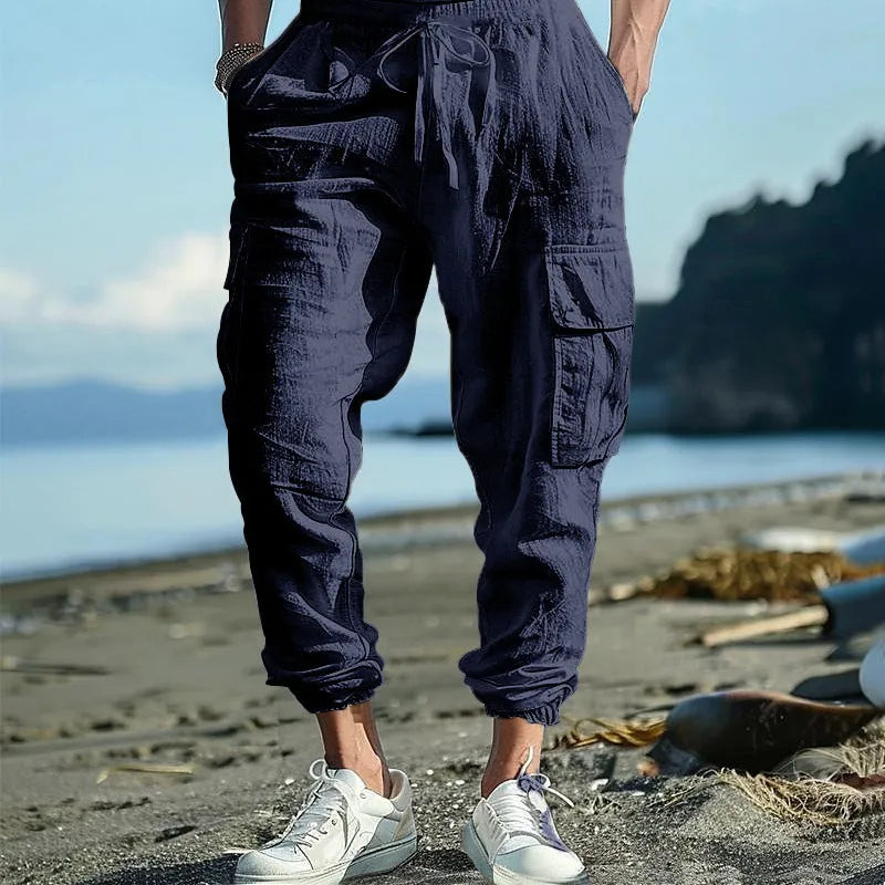 Men's solid colour linen casual trousers with ankle-tied cuffs, multiple pockets, and a drawstring waist