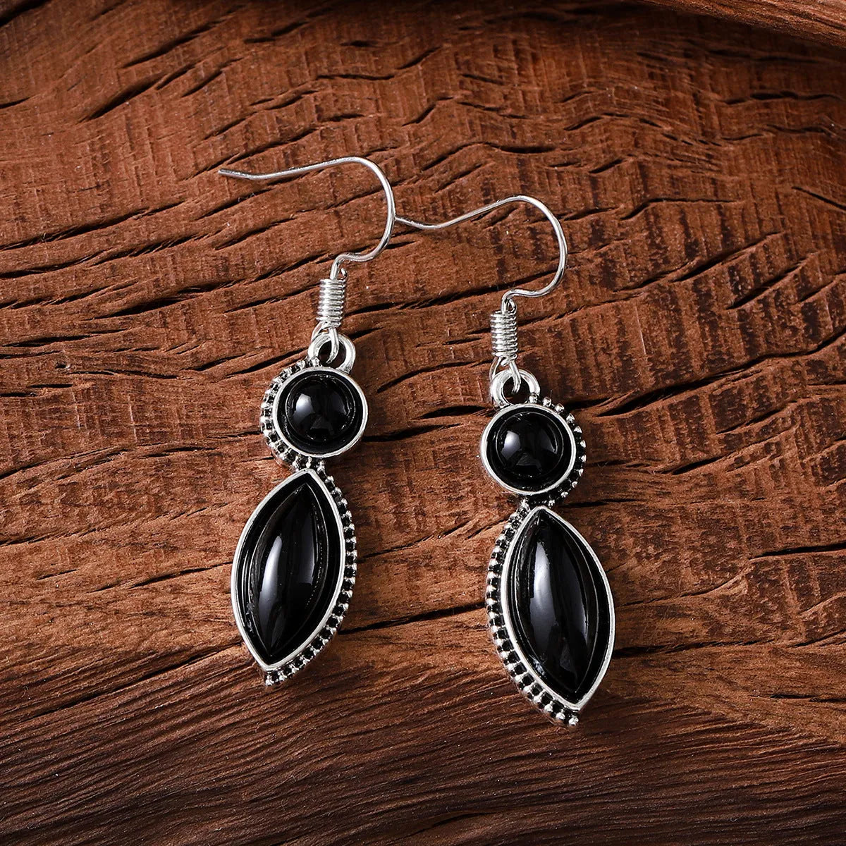 A pair of black and purple vintage geometric pendant earrings with bohemian style on a white background.
