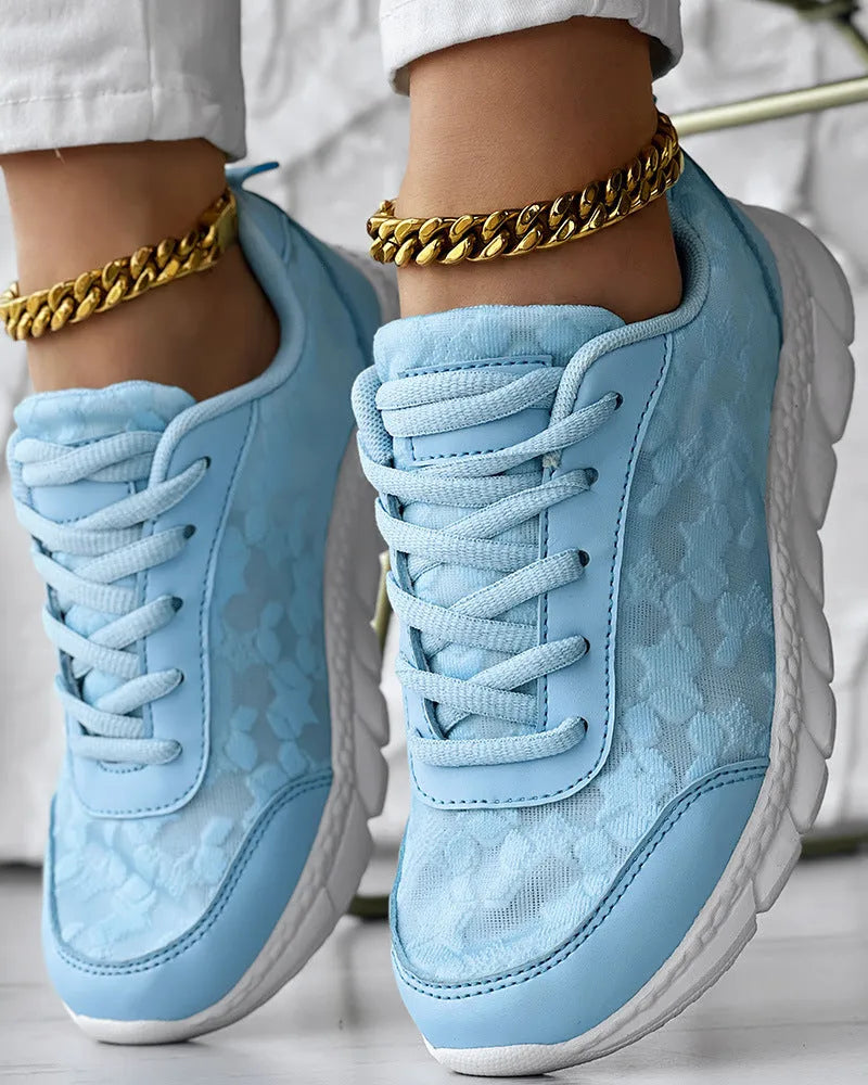 Women's white canvas running shoes with soft sole and flat heel on a plain background.