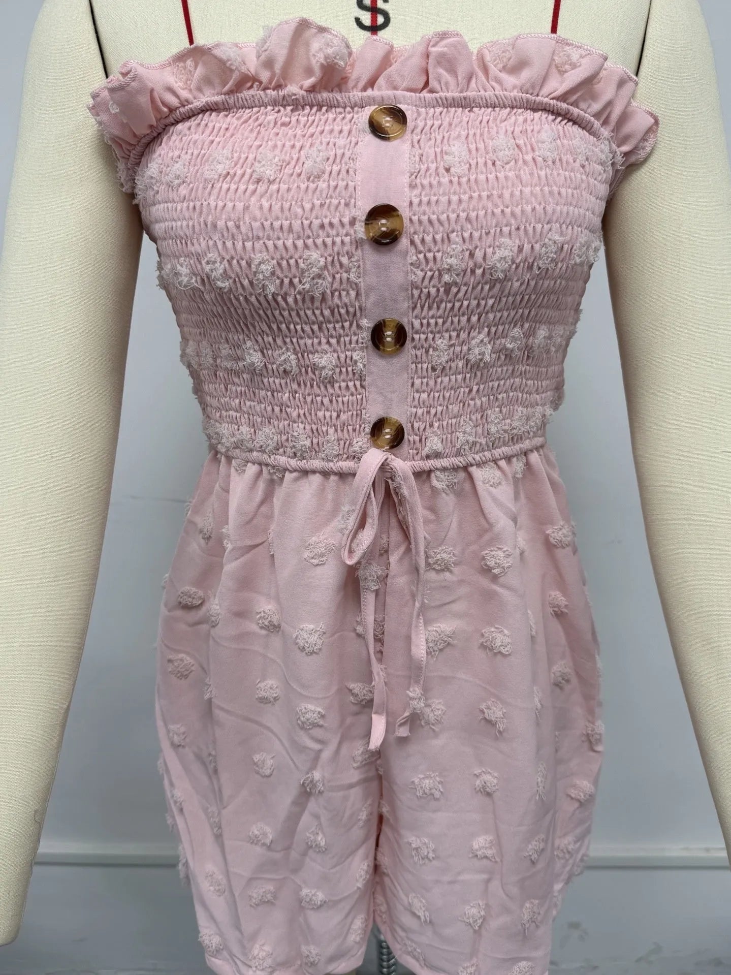 Women's sleeveless off-shoulder jumpsuit in solid colour with elastic waist and button details
