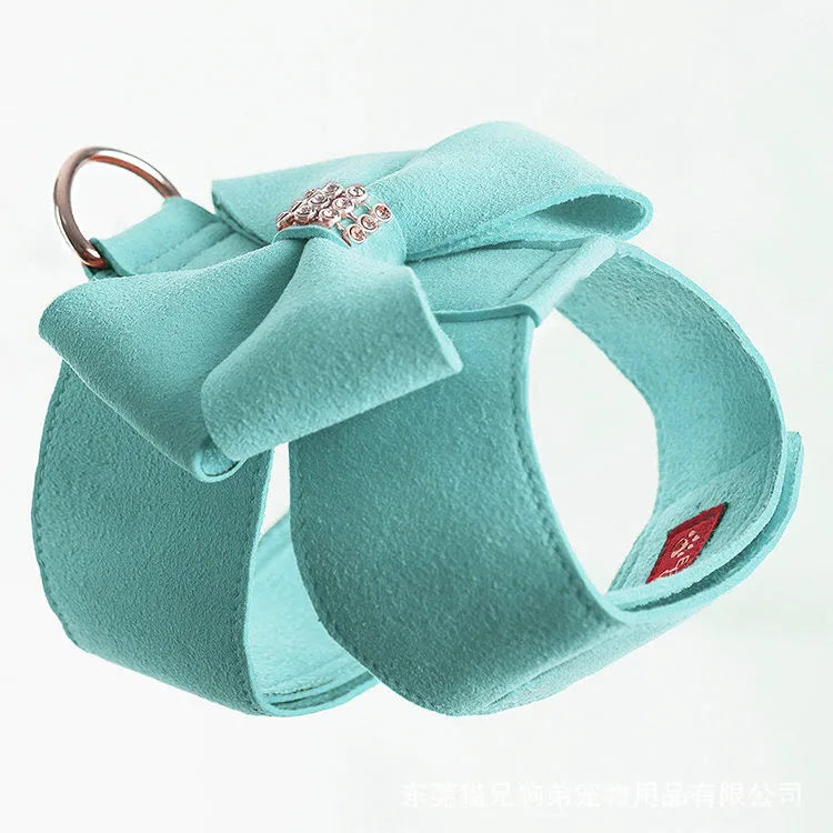 A pink microfiber dog chest strap with a large decorative bowknot, shown alongside blue and orange colour options.