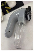 Grey portable electric pet hair removal brush with soft rubber head for grooming dogs and cleaning sofas.
