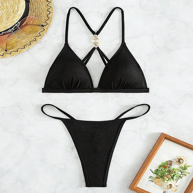 Black women's hollow backless triangle bikini top with matching bottoms on a mannequin.