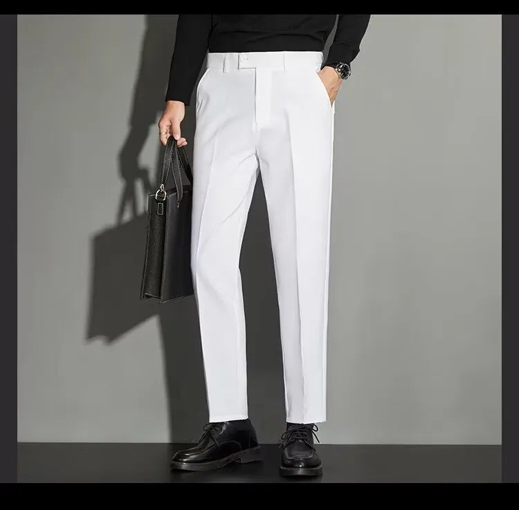 Man wearing straight leg ankle-length suit trousers in a light colour, showing the drape of the fabric.