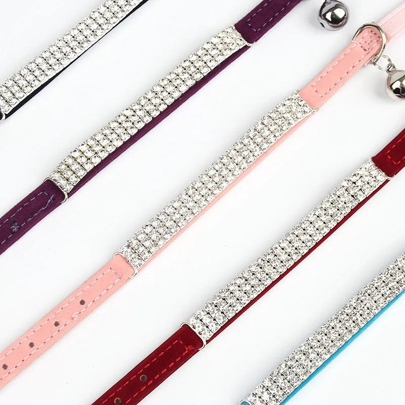 Adjustable velvet cat collar with rhinestones on a black background showing red, blue, and purple colour options.