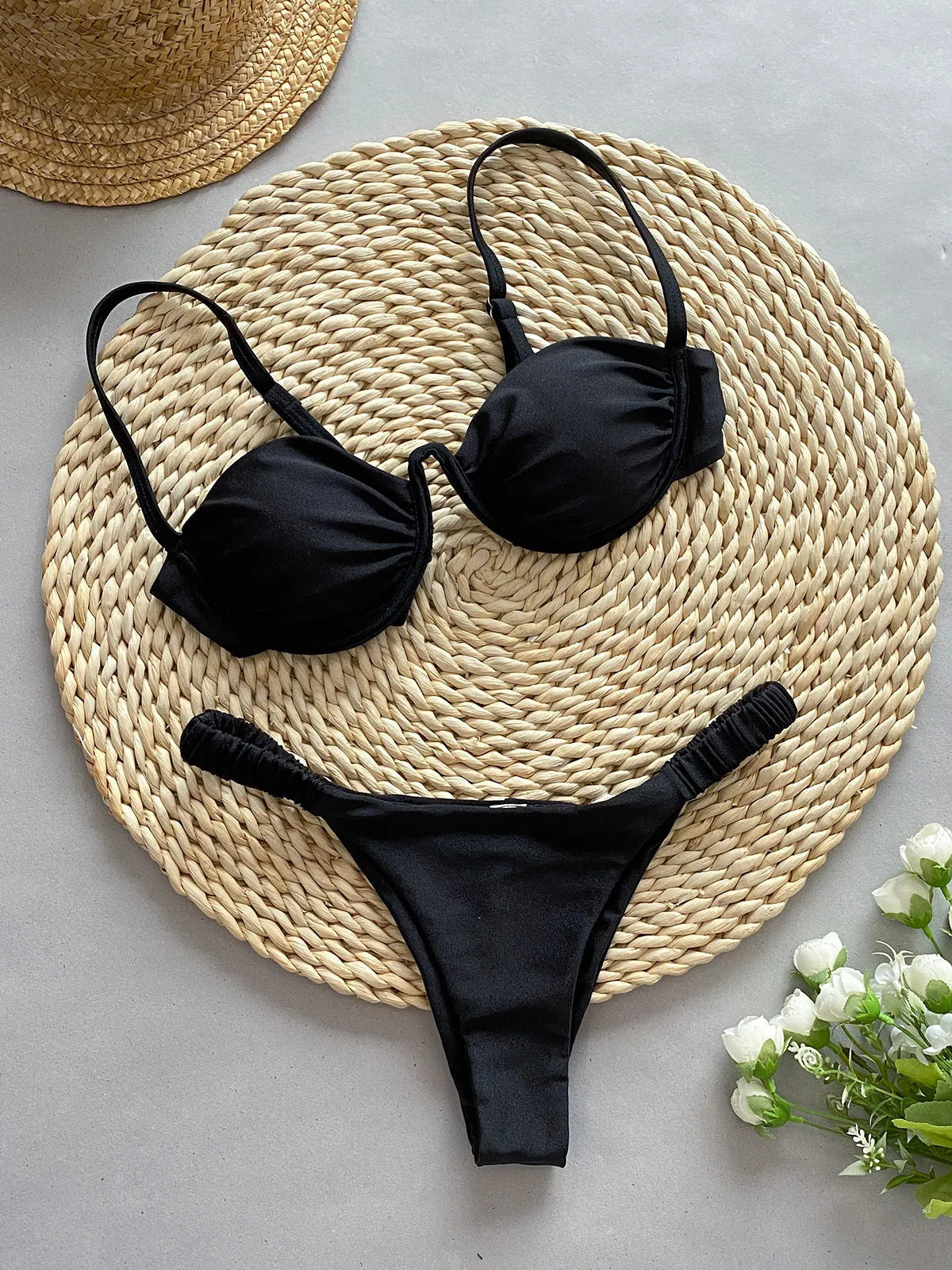 Women's black underwire bikini swimsuit set with split briefs on a neutral background.
