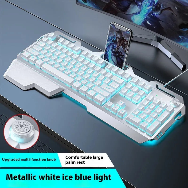 Aluminium gaming keyboard with volume knob, shown in metal grey with RGB lighting alongside optional macro mouse and headset.