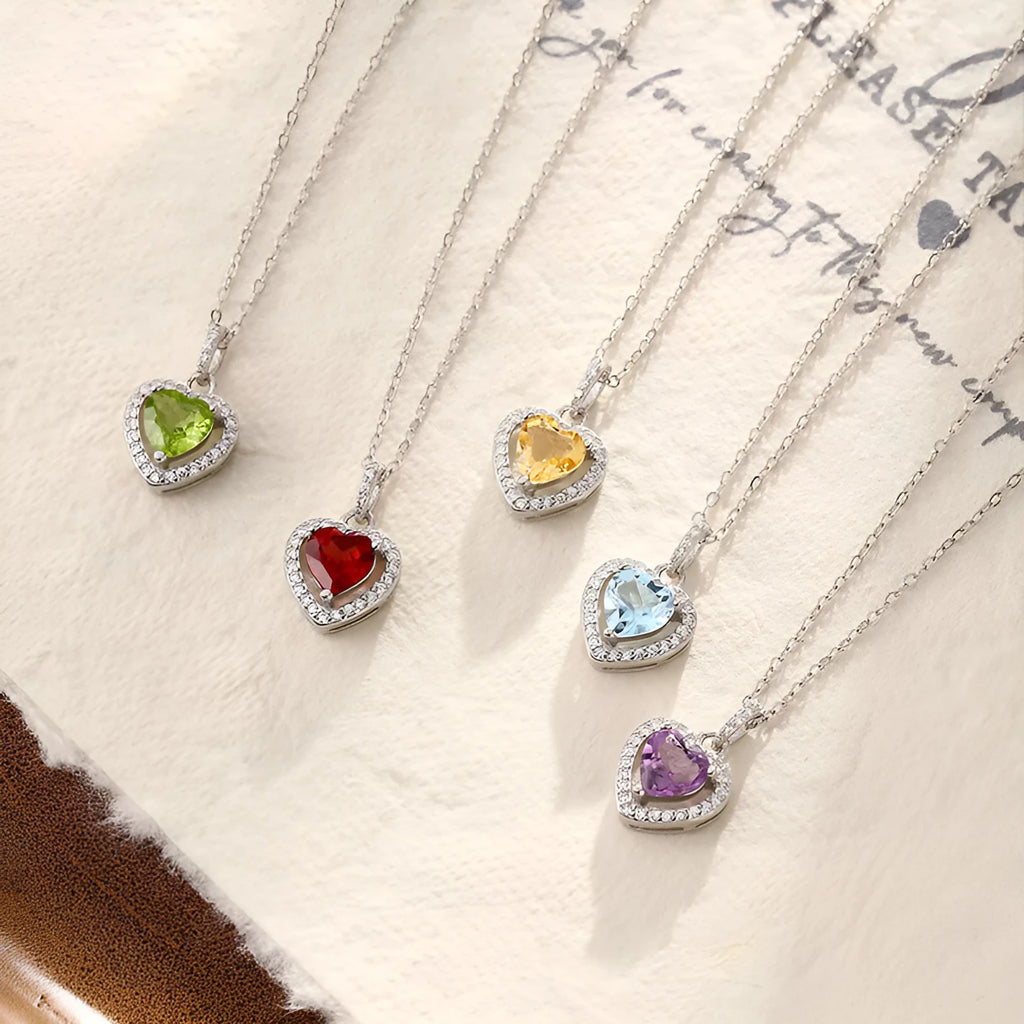 Women's sterling silver necklace with heart-shaped pendant containing natural gemstone on adjustable cross chain