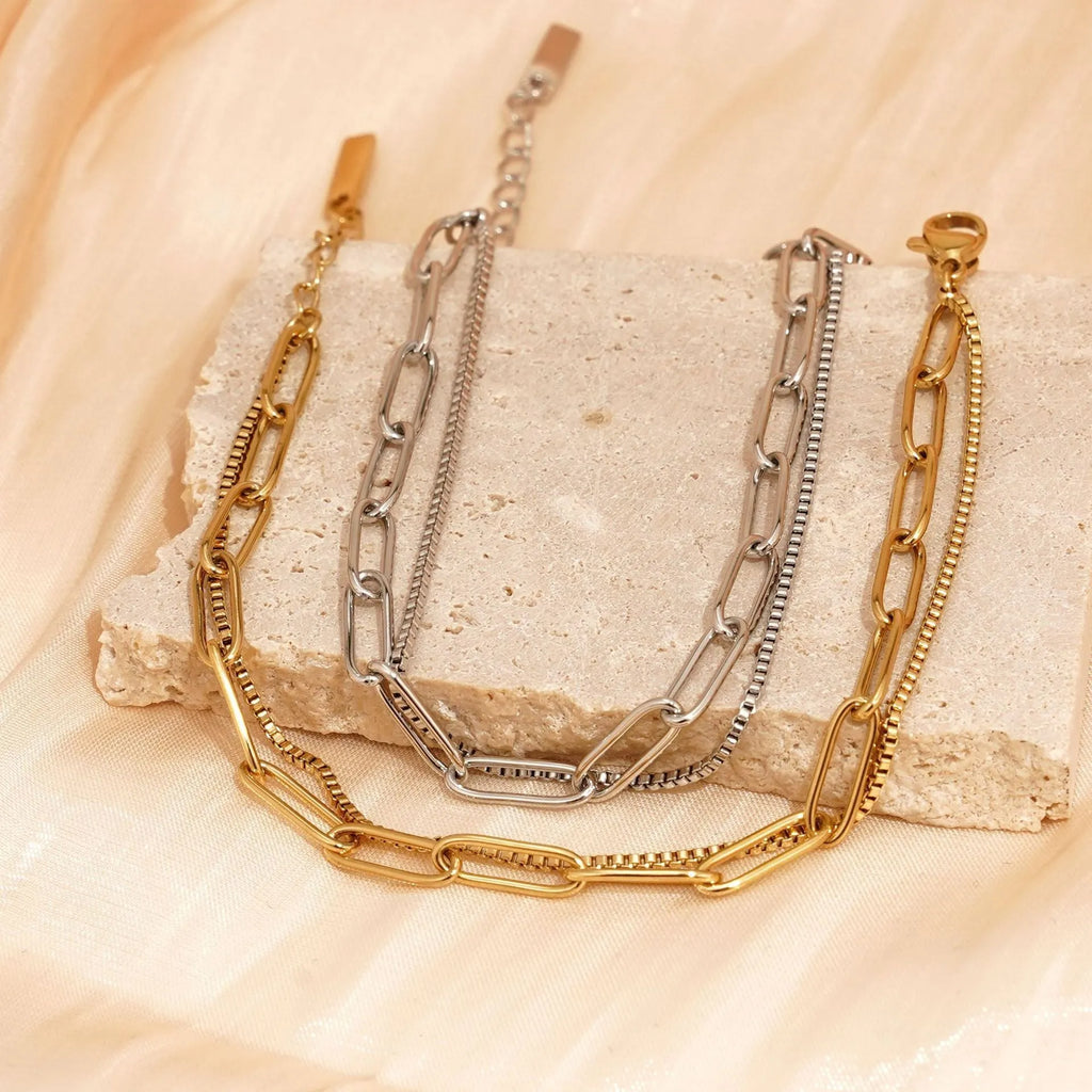 Gold titanium steel electroplated women's bracelet with geometric double layer chain design.
