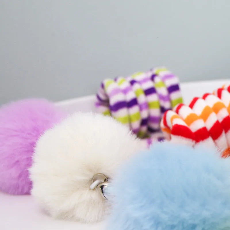 Kitten playing with hanging spring toy featuring inflatable ball and suction cup mount in various colours