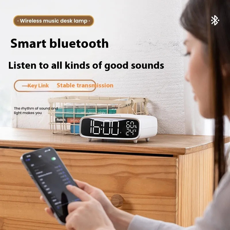 White wireless charger Bluetooth speaker alarm clock with LED night light on bedside table