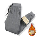 Man wearing grey fleece-lined cotton oversized track pants with a drawstring waistband.