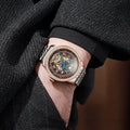 Men's stainless steel mechanical watch with transparent case back showing movement and butterfly buckle