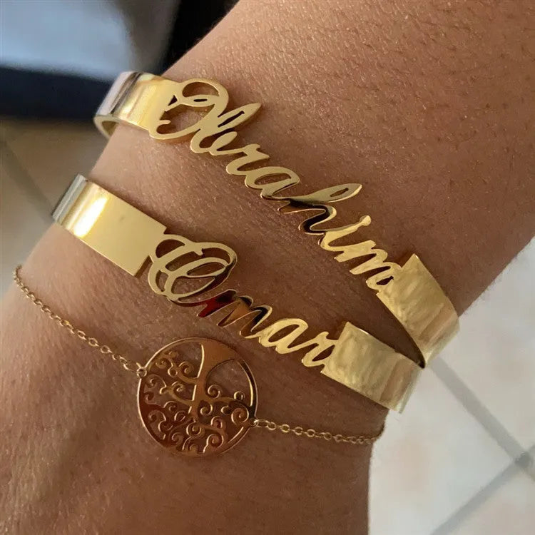 Custom engraved name bangle in stainless steel, silver colour finish, shown on a flat surface