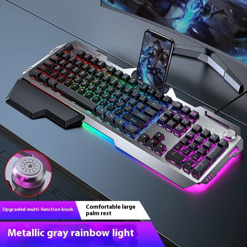 Aluminium gaming keyboard with volume knob, shown in metal grey with RGB lighting alongside optional macro mouse and headset.