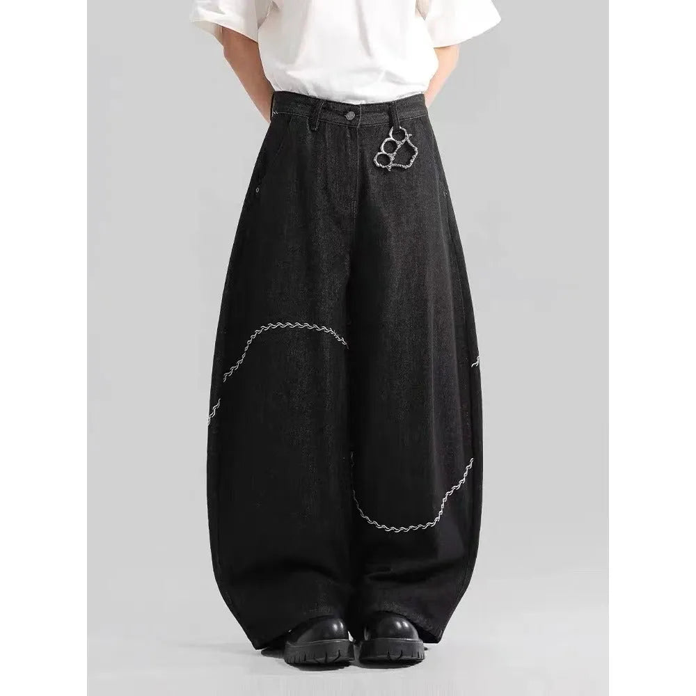 Men's black straight-leg denim trousers with a zip fly on a mid waist, shown in a casual street style.
