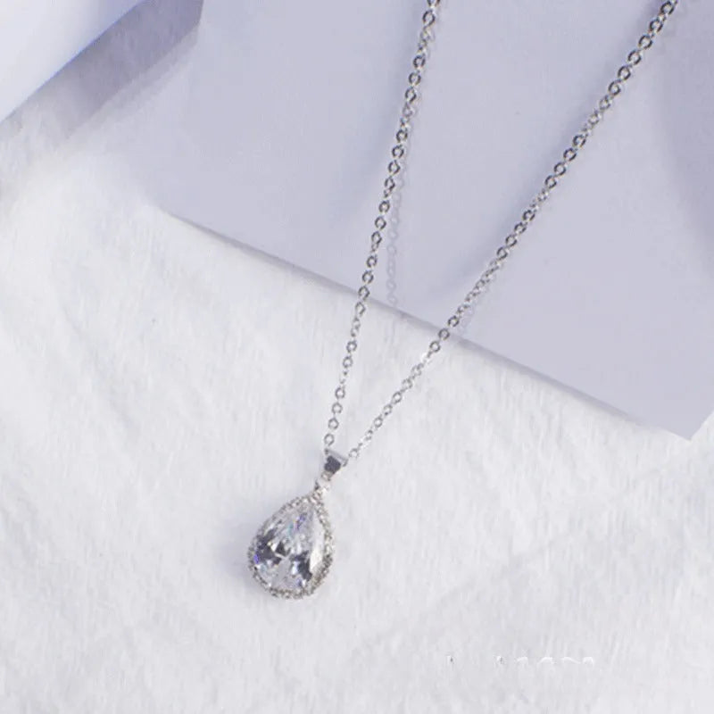 Pink water drop shaped rhinestone necklace with rose gold electroplated alloy pendant on white background