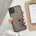 Black anti-blue-light soft-touch iPhone case for multiple models on a table.