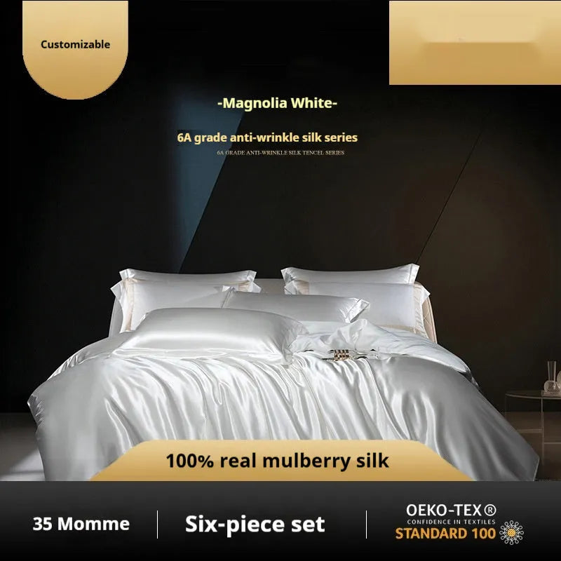 Silk four-piece quilt cover set in a solid colour, shown in a bedroom setting on a bed.