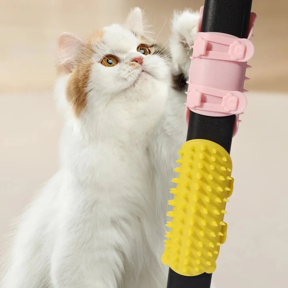 Silicone cat grooming comb with adjustable strap mounted on a table leg, shown in assorted colours.