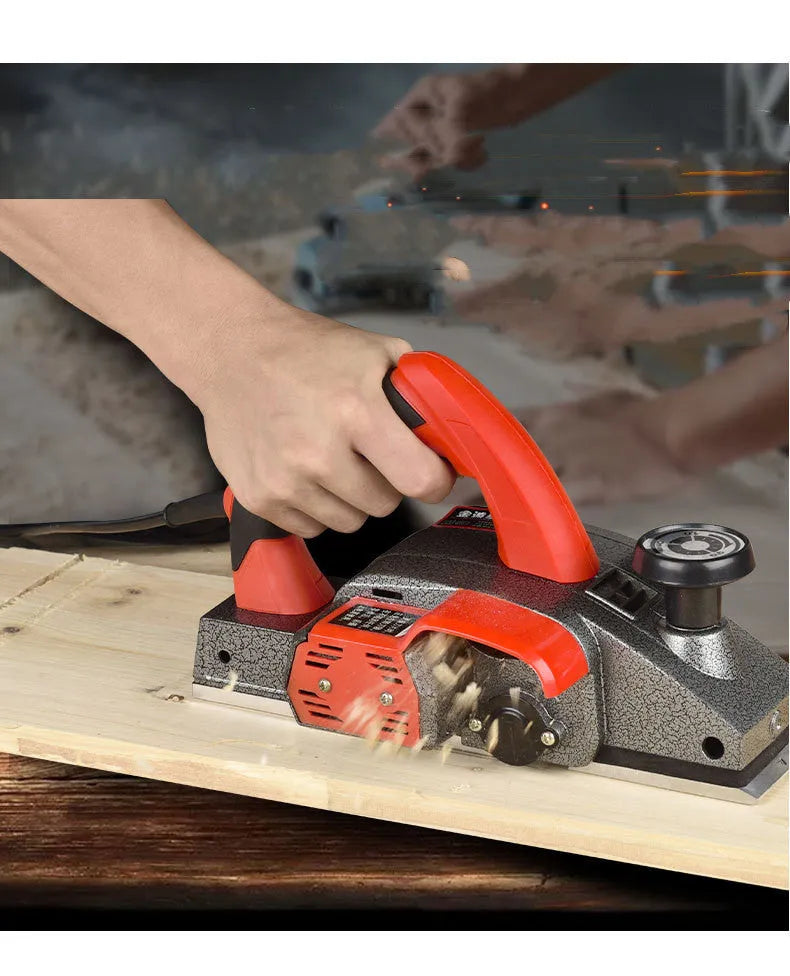 Red electric wood planer with aluminium housing showing 82mm planing width and power specifications