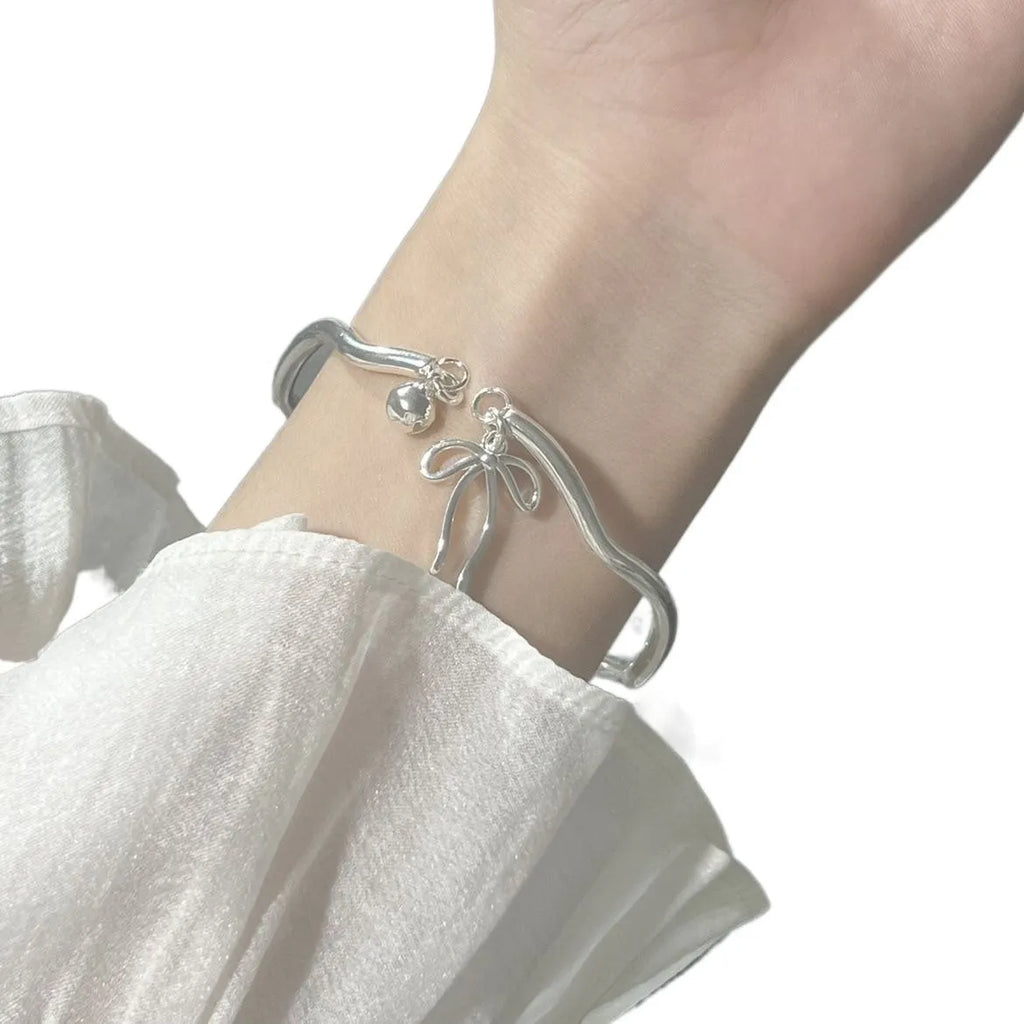 Silver bow adjustable girlfriends bracelet with bell opening clasp and sliding charm