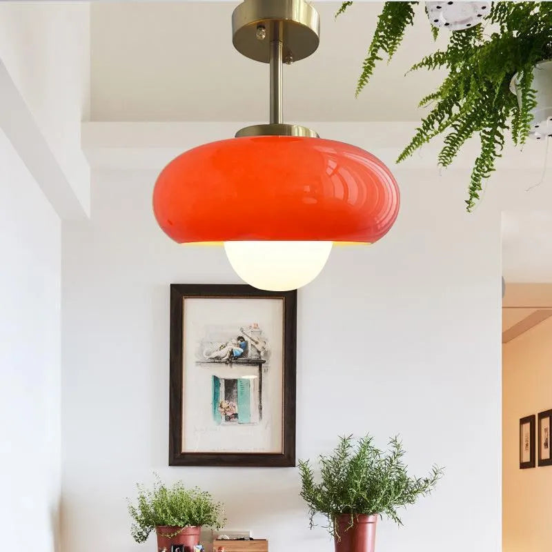 Three-headed Bauhaus pendant light with milky white glass egg tart shades hanging from a ceiling.