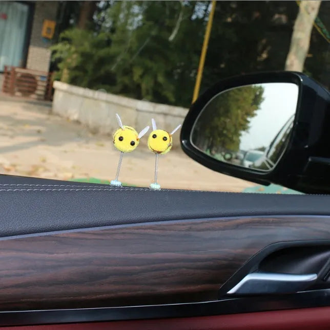 Spring-loaded bee car decoration with fur texture swinging from dashboard