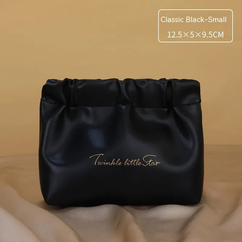 Leather travel toiletry bag in caramel mocha colour showing storage compartments and decorative letter details