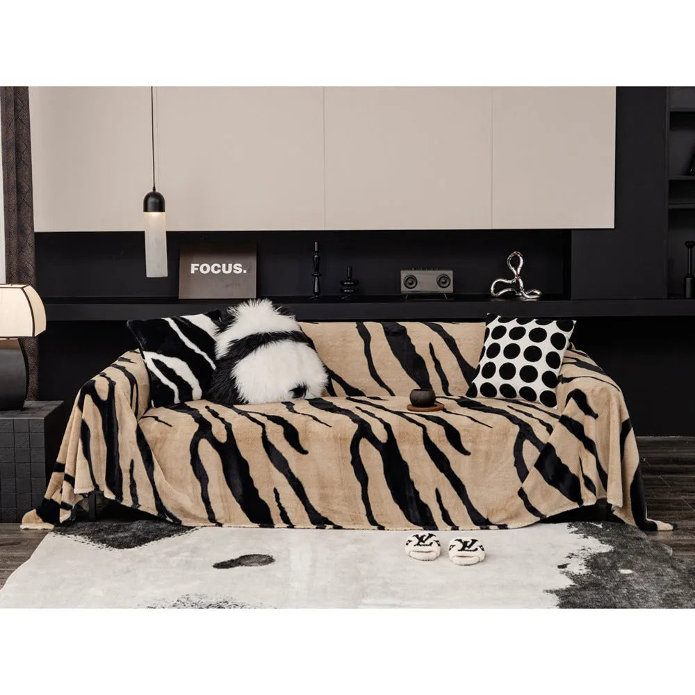Thickened flannel zebra pattern sofa cover in caramel or black draping over a sofa with non-slip texture visible