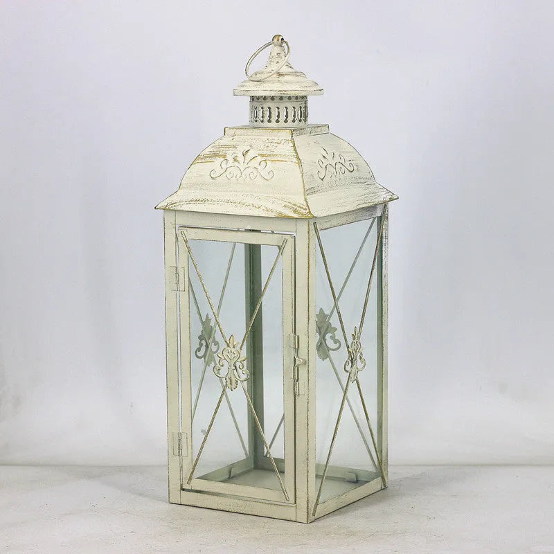 Black wrought iron floor-standing storm lantern with tempered glass panels for outdoor candle lighting
